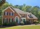 Charming two-story brick home with manicured lawn and mature trees at 610 Brington Close, Alpharetta, GA 30022