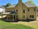 A home's back exterior features a covered patio, large windows, and lush lawn at 713 Parkside Dr, Woodstock, GA 30188