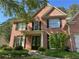 Brick two-story house featuring black shutters, an attached garage, and a landscaped front yard at 713 Parkside Dr, Woodstock, GA 30188