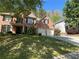 Traditional brick home with a manicured lawn, lush trees, and a two-car garage at 713 Parkside Dr, Woodstock, GA 30188