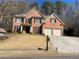 Charming two-story brick home featuring a two-car garage and well-manicured front lawn at 713 Parkside Dr, Woodstock, GA 30188