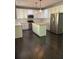 Spacious kitchen featuring white cabinets, stainless steel appliances, and a large island with butcher block top at 713 Parkside Dr, Woodstock, GA 30188