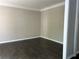 Living room with decorative molding, neutral walls, and dark wood floors with an open doorway at 713 Parkside Dr, Woodstock, GA 30188