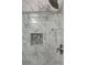 Elegant shower with marble-look tiling and a recessed shelf with pebble accents at 713 Parkside Dr, Woodstock, GA 30188