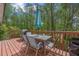 Outdoor wooden deck with an outdoor dining set and a view of the surrounding lush greenery at 2591 Boulder Hill Se Ct, Atlanta, GA 30316