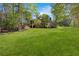 Lush backyard with a sprawling lawn, mature trees, and a charming view of home's exterior with covered patio at 3 Woodlawn Ne Dr, Marietta, GA 30067