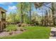 Expansive backyard of a brick home with lush lawn and mature trees, offering a serene and private outdoor space at 3 Woodlawn Ne Dr, Marietta, GA 30067