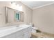Bright bathroom with white vanity, framed mirror, toilet, and tile flooring at 3 Woodlawn Ne Dr, Marietta, GA 30067