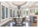 Bright dining area featuring a glass table, modern chandelier, and views of the backyard at 3 Woodlawn Ne Dr, Marietta, GA 30067