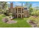 Back exterior view of home with brickwork, balcony, manicured lawn and gardens, creating a serene outdoor living space at 3 Woodlawn Ne Dr, Marietta, GA 30067