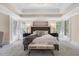 Comfortable main bedroom with tray ceilings and a cozy sitting bench at the end of the bed at 3 Woodlawn Ne Dr, Marietta, GA 30067