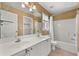 Bright bathroom featuring double sinks, white cabinets, and a shower-tub combo with neutral-color tiles at 1008 Lena Nw St, Atlanta, GA 30314