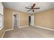 Spacious bedroom with neutral tones, ceiling fan, carpeted floor and ensuite bathroom at 1008 Lena Nw St, Atlanta, GA 30314