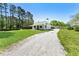 Charming home with a long gravel driveway, green roof, and mature trees at 3556 Finch Sw Rd, Powder Springs, GA 30127