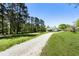 Scenic view of a well-maintained home with a long gravel driveway and mature trees at 3556 Finch Sw Rd, Powder Springs, GA 30127