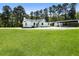 A charming white home with lush green lawn, mature trees, and long driveway at 3556 Finch Sw Rd, Powder Springs, GA 30127