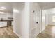 Hallway with modern wood flooring leading to a newly renovated kitchen with stainless steel appliances at 3556 Finch Sw Rd, Powder Springs, GA 30127