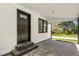 View of the entry and portico of the home with a black door and exterior trim at 3556 Finch Sw Rd, Powder Springs, GA 30127