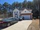 Two-story home showcasing light siding, a two-car garage, and a driveway with two vehicles at 3578 Willow Spring Ct, Decatur, GA 30034