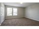 This bedroom has carpet, neutral colored walls, and two windows that bring in natural light at 3721 Longview Dr, Douglasville, GA 30135