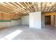 Unfinished basement with exposed wood framing, concrete floor, and a white door at 417 Newland Way, Acworth, GA 30102