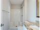 A clean bathroom featuring a shower with built-in seating, a granite countertop, and white walls at 6895 Brown S Dr, Fairburn, GA 30213