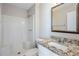 A clean bathroom featuring a shower with built-in seating, a granite countertop, and white walls at 6895 Brown S Dr, Fairburn, GA 30213