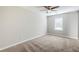 A bright bedroom featuring neutral walls, carpet flooring, ceiling fan, and a window that brings in ample natural light at 6895 Brown S Dr, Fairburn, GA 30213