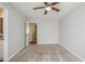 A cozy bedroom featuring neutral walls, carpet flooring, ceiling fan, and a door that leads to another room at 6895 Brown S Dr, Fairburn, GA 30213