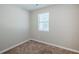 A bedroom featuring neutral walls, carpet flooring, and a window that brings in ample natural light at 6895 Brown S Dr, Fairburn, GA 30213
