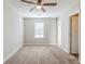 A cozy bedroom featuring neutral walls, carpet flooring, ceiling fan, and a window that brings in ample natural light at 6895 Brown S Dr, Fairburn, GA 30213