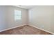 A well-lit bedroom featuring neutral walls, carpet flooring, and a window that brings in ample natural light at 6895 Brown S Dr, Fairburn, GA 30213