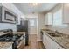 Well-lit kitchen featuring stainless steel appliances, granite countertops, and white cabinets at 6895 Brown S Dr, Fairburn, GA 30213