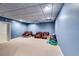Finished basement with neutral carpet, cooling fan and comfortable seating at 7635 Blandford Pl, Atlanta, GA 30350
