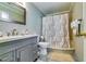 Bathroom features a vanity with storage, a shower with neutral curtain, and tiled flooring at 7635 Blandford Pl, Atlanta, GA 30350