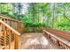 Spacious wooden deck with railing and built-in bench, ideal for relaxing and enjoying the wooded views at 7635 Blandford Pl, Atlanta, GA 30350