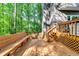 Wooden deck features built in bench and stairway access to the home, surrounded by nature at 7635 Blandford Pl, Atlanta, GA 30350
