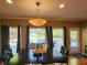 Dining area with view of the pool, featuring modern lighting, dark wood table, and stylish chairs at 7635 Blandford Pl, Atlanta, GA 30350