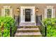 Charming front entrance featuring stone steps, black railings, and decorative outdoor lighting at 7635 Blandford Pl, Atlanta, GA 30350