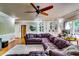 Open-concept living room featuring a modern ceiling fan, hardwood floors, built-in shelves, and ample seating at 7635 Blandford Pl, Atlanta, GA 30350