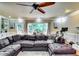 Spacious living room with oversized couch, ceiling fan, and natural light at 7635 Blandford Pl, Atlanta, GA 30350