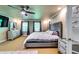 Bright main bedroom featuring a ceiling fan, tufted headboard, sitting area, and natural light at 7635 Blandford Pl, Atlanta, GA 30350