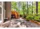 Patio with wooden staircase surrounded by lush greenery, seamlessly blending indoor-outdoor living at 7635 Blandford Pl, Atlanta, GA 30350
