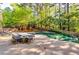 Backyard with luxurious pool, lush greenery, lounge chairs and outside dining area, great for entertaining at 7635 Blandford Pl, Atlanta, GA 30350