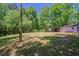 Open backyard with trees and partial view of the house offers a serene outdoor setting at 210 Meadowbrook Dr, Mcdonough, GA 30253