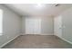 Carpeted bedroom featuring natural light, a standard closet, and an entry door at 210 Meadowbrook Dr, Mcdonough, GA 30253
