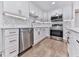 Modern kitchen featuring white cabinetry, stainless steel appliances, stone countertops, and a stylish backsplash at 221 Wonewok Dr, Canton, GA 30114