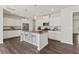 Kitchen features an island with seating, stainless steel appliances, pendant lighting, and modern white cabinetry at 407 Newland Way, Acworth, GA 30102