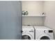 Functional laundry room is equipped with modern washer and dryer and storage shelf at 1331 Iverson Ne St # A, Atlanta, GA 30307