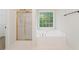 Bright bathroom featuring a large soaking tub and separate shower with glass doors at 160 Winter Park Ln, Powder Springs, GA 30127